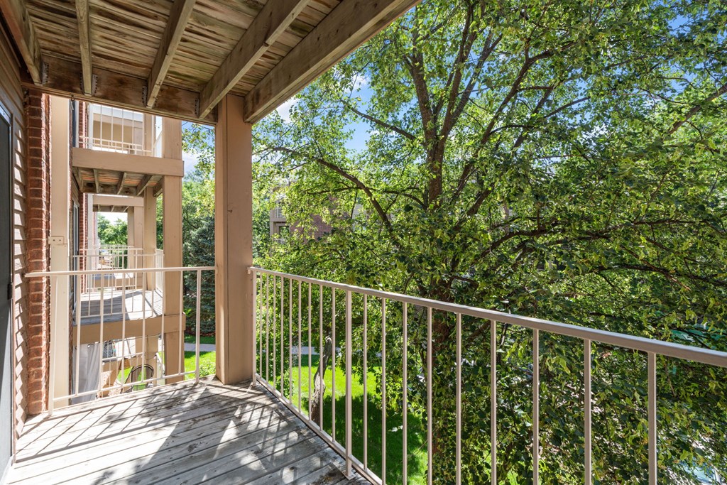a balcony with a view of a yard and trees
