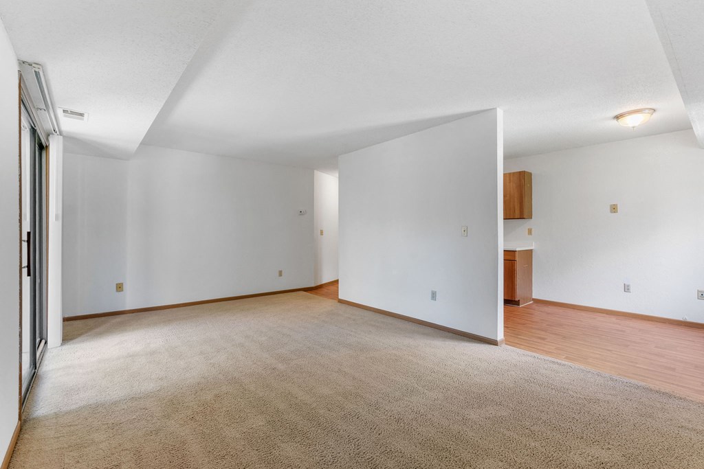 an empty living room with white walls and wood flooring
