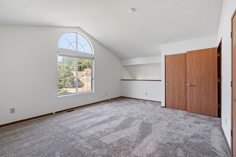 an empty living room with a large window and a door