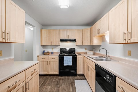 A kitchen with wooden cabinets and black appliances.