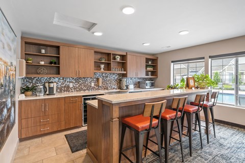 A kitchen with a bar area and three stools.