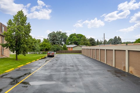 A long driveway with a car parked at the end.