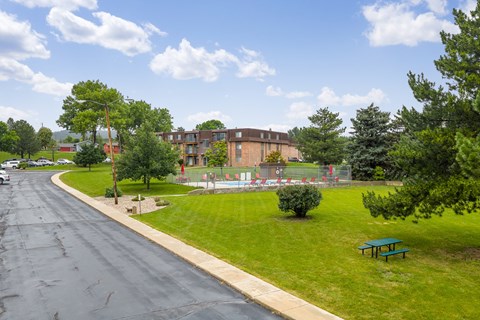 A road with a green bench on the side.