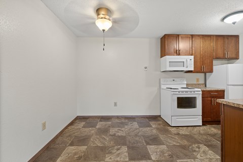 A kitchen with a white oven and microwave.