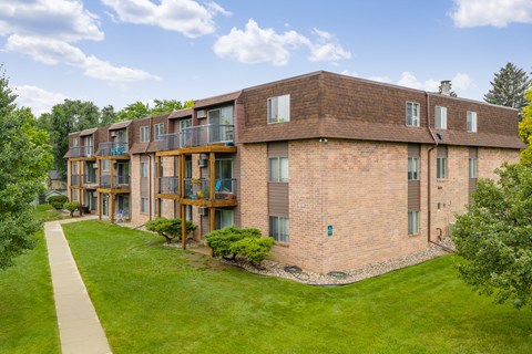 A brick building with a green lawn in front.