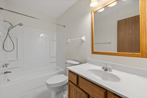 A white bathroom with a toilet, sink, and tub.