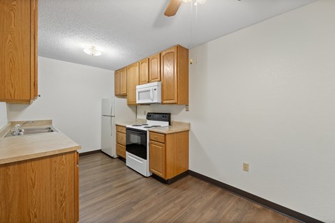 A kitchen with wooden cabinets and appliances.