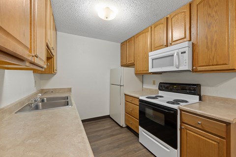 A kitchen with wooden cabinets and white appliances.