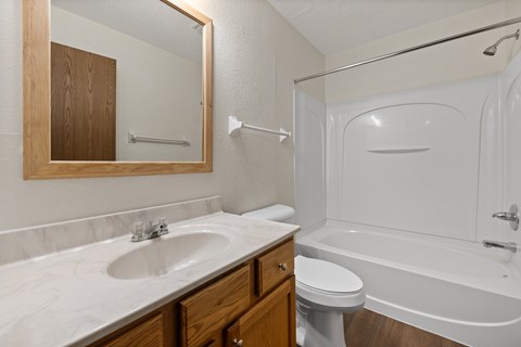 A white bathroom with a sink, toilet, and bathtub.