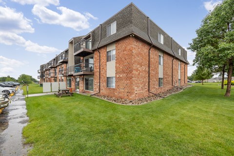 A red brick building with a green lawn in front.