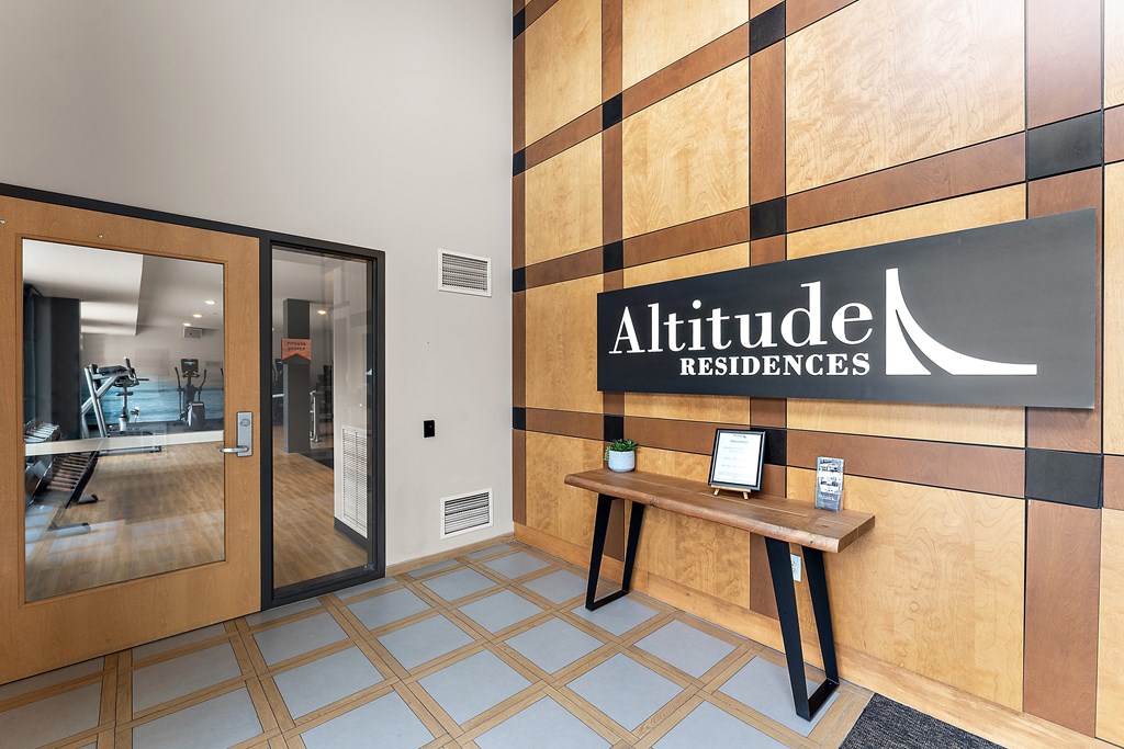 A lobby with Altitude Residences sign on the wall.