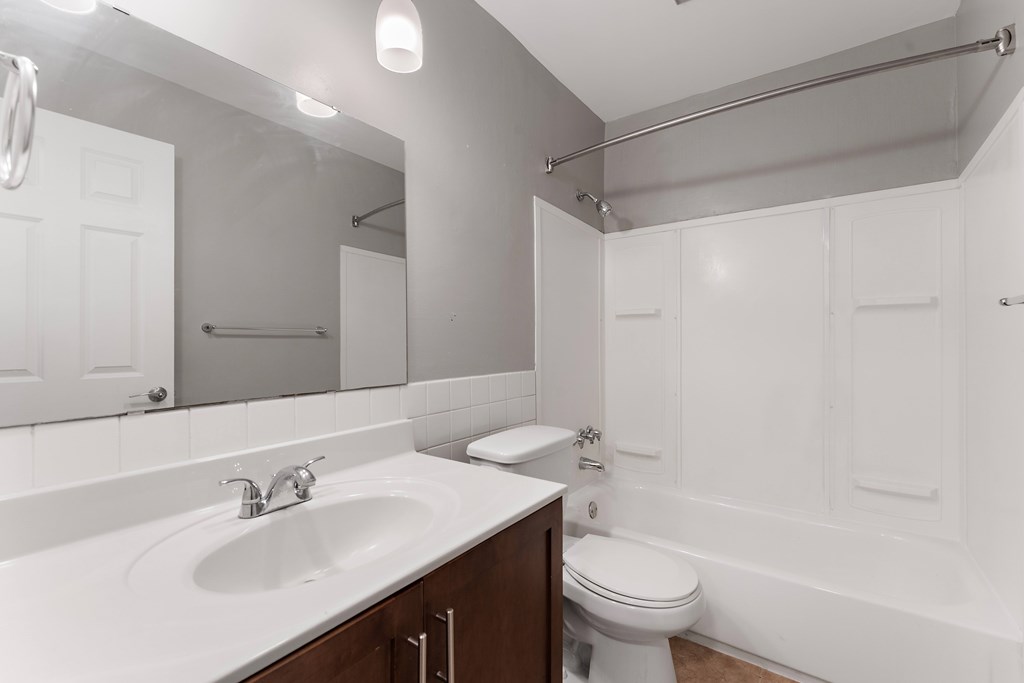 A white bathroom with a sink, toilet and bathtub.
