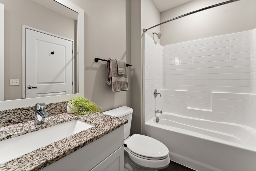 A white toilet sits next to a sink in a bathroom.