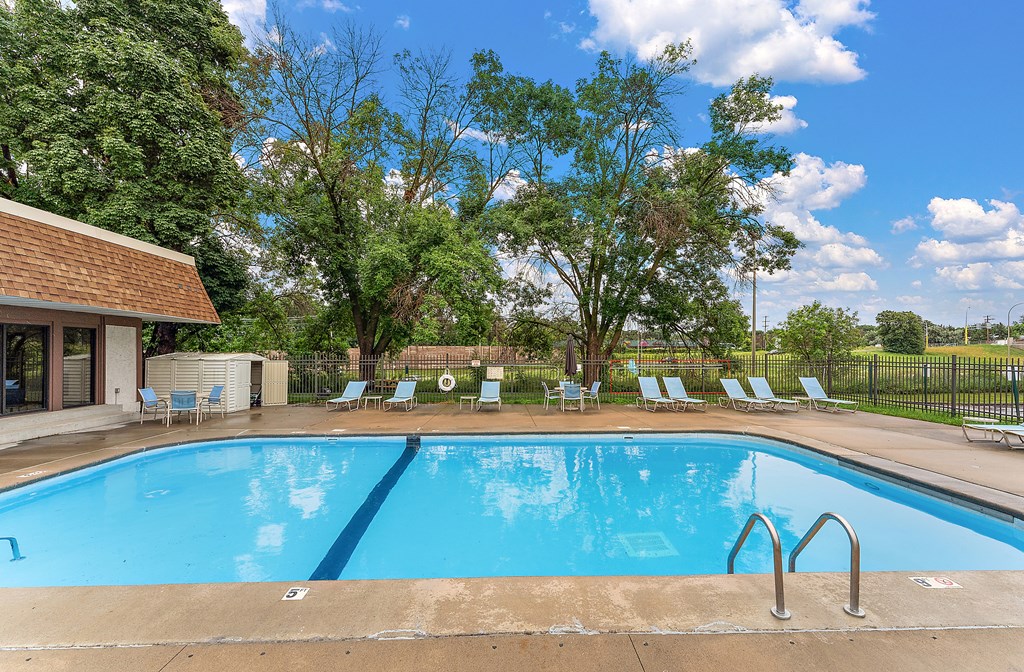 A large blue swimming pool with a metal ladder in the middle.