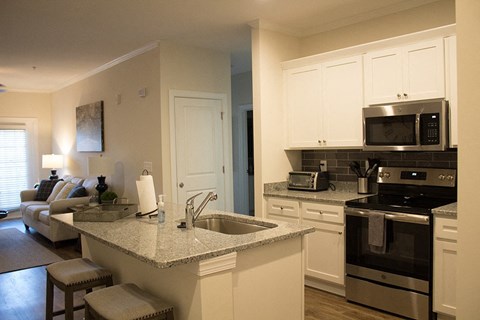 a kitchen and living room with a granite counter top