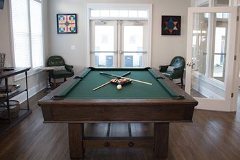 a game room with a pool table and chairs  at The Retreat at Sumter, Sumter