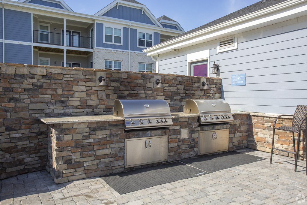 an outdoor kitchen with two grills in front of a house at The Retreat at Sumter, Sumter, South Carolina