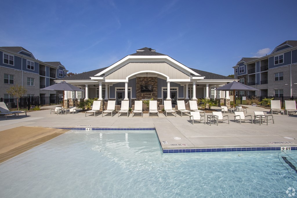 a resort style pool with lounge chairs and umbrellas at The Retreat at Sumter, Sumter, South Carolina