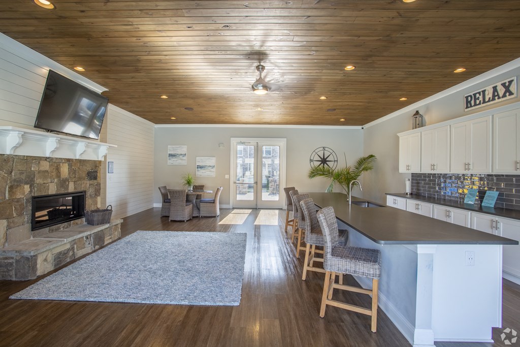 a kitchen and living room with a fireplace and a tv on the wall at The Retreat at Sumter, Sumter, South Carolina