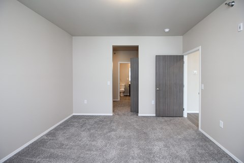 A spacious room with a carpeted floor and two doors.