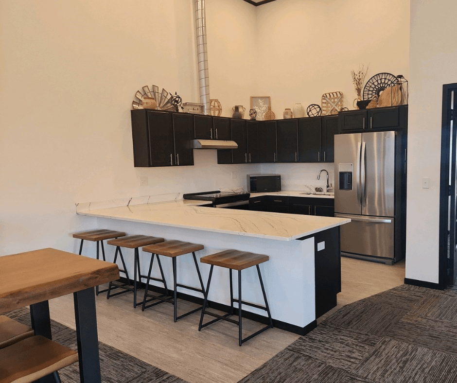 A kitchen with a white countertop and black cabinets.