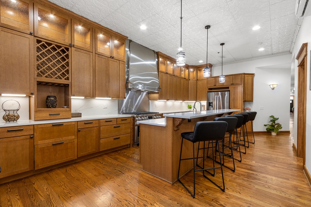 A kitchen with wooden cabinets and black bar stools.
