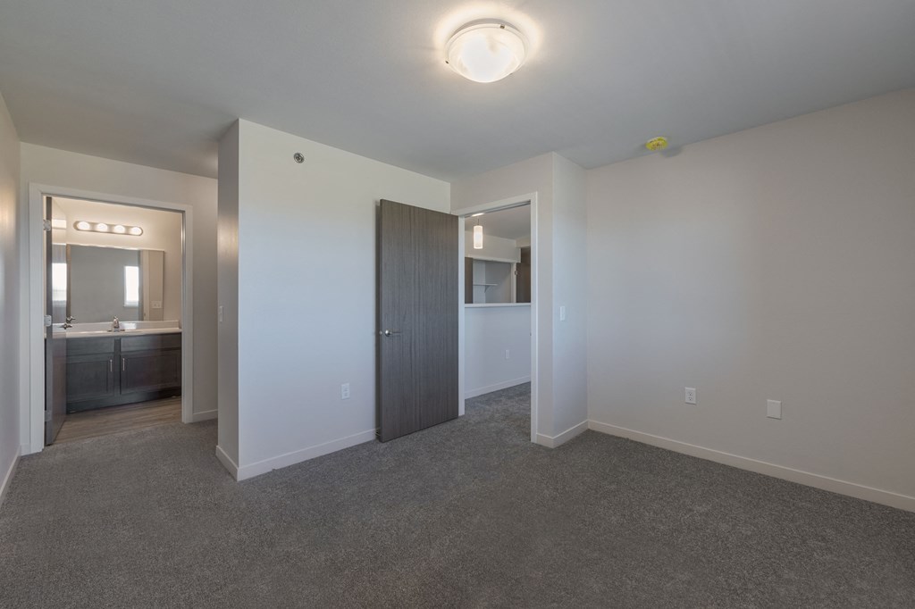a bedroom with grey carpet and white walls