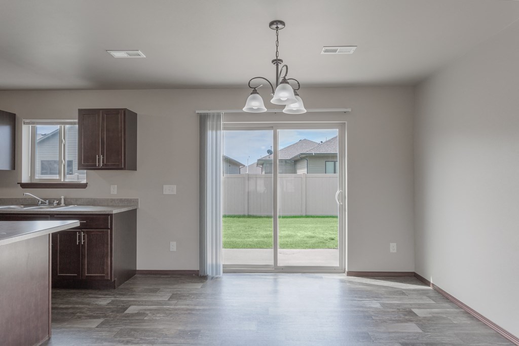 an empty kitchen with a sliding glass door to the backyard