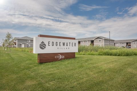 the preserve at edgewater village sign in the grass with houses in the background