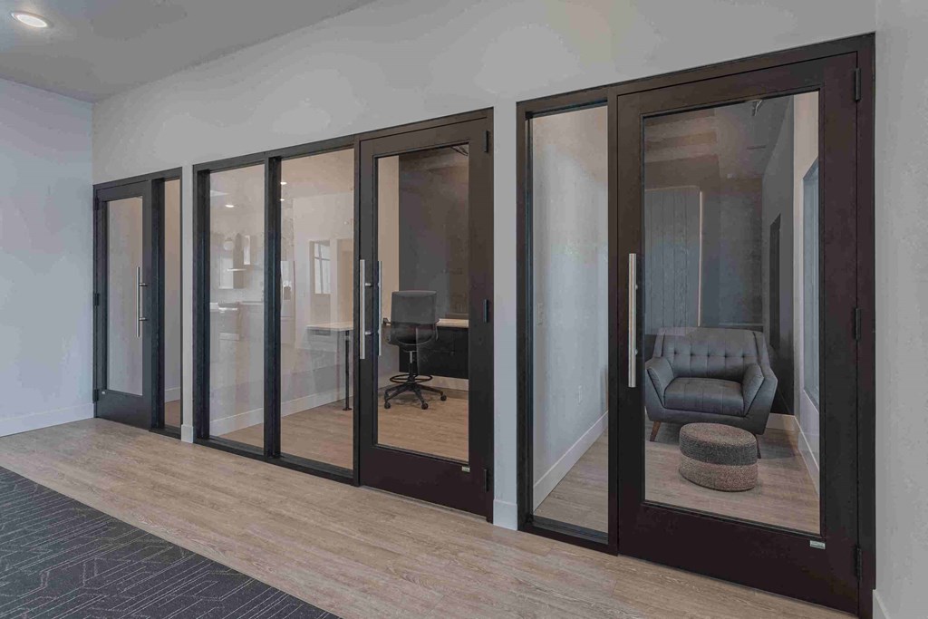 a room with large glass windows and a chair