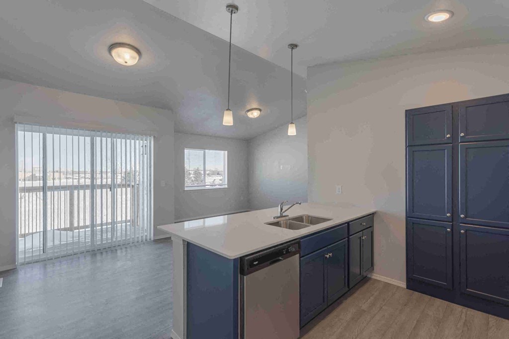 an empty kitchen with blue cabinets and a sink