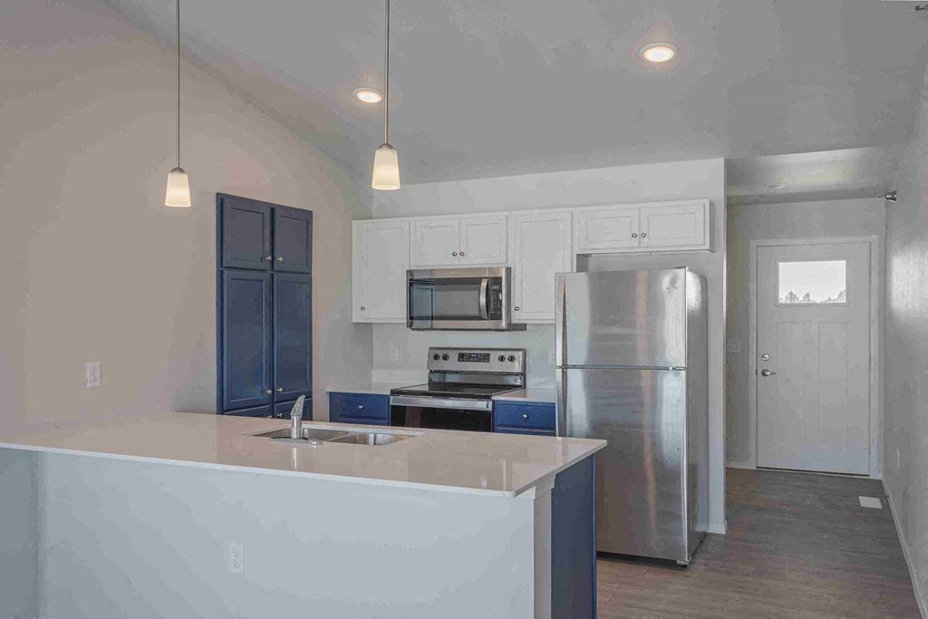 a kitchen with white cabinets and a stainless steel refrigerator