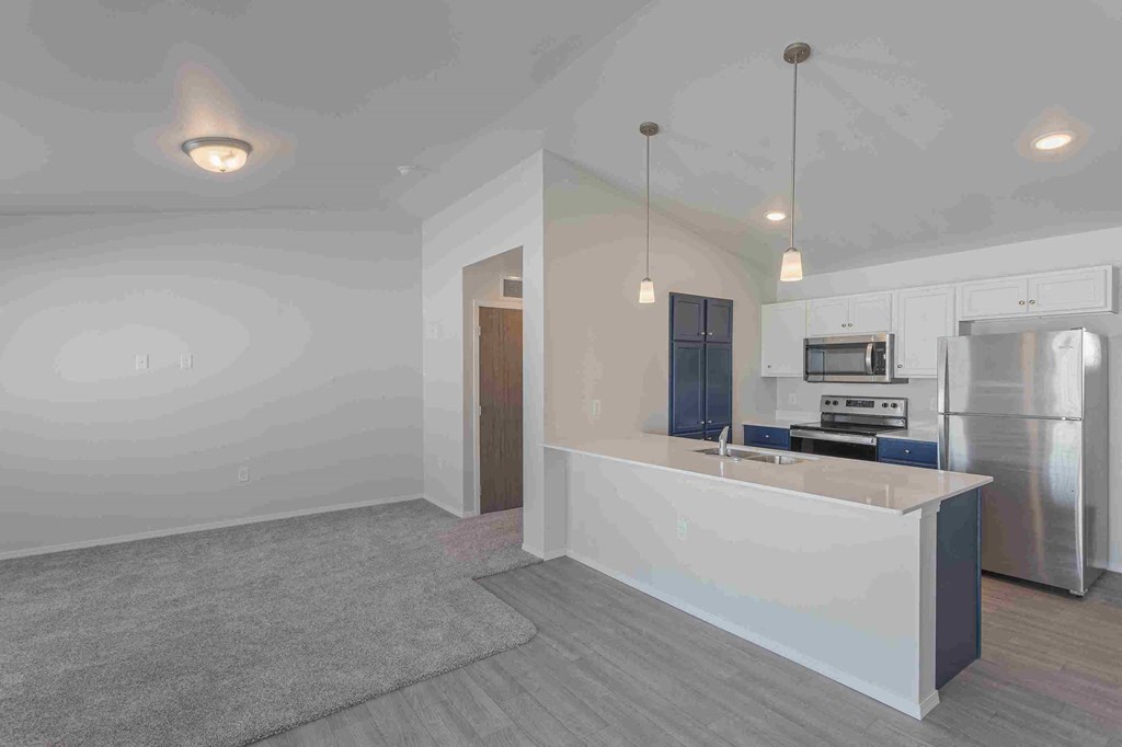 a kitchen with a large island and a stainless steel refrigerator