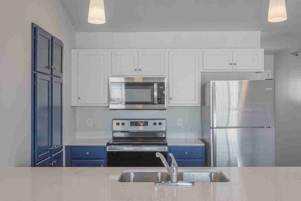 a kitchen with white cabinets and stainless steel appliances