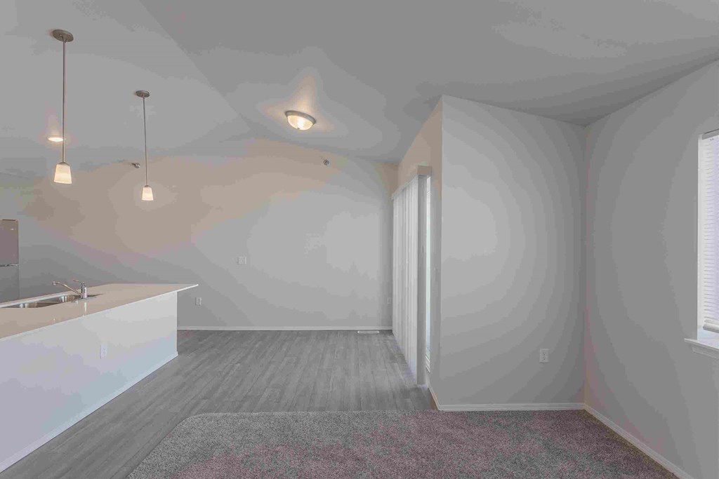 an empty room with a sink and a door to a bathroom