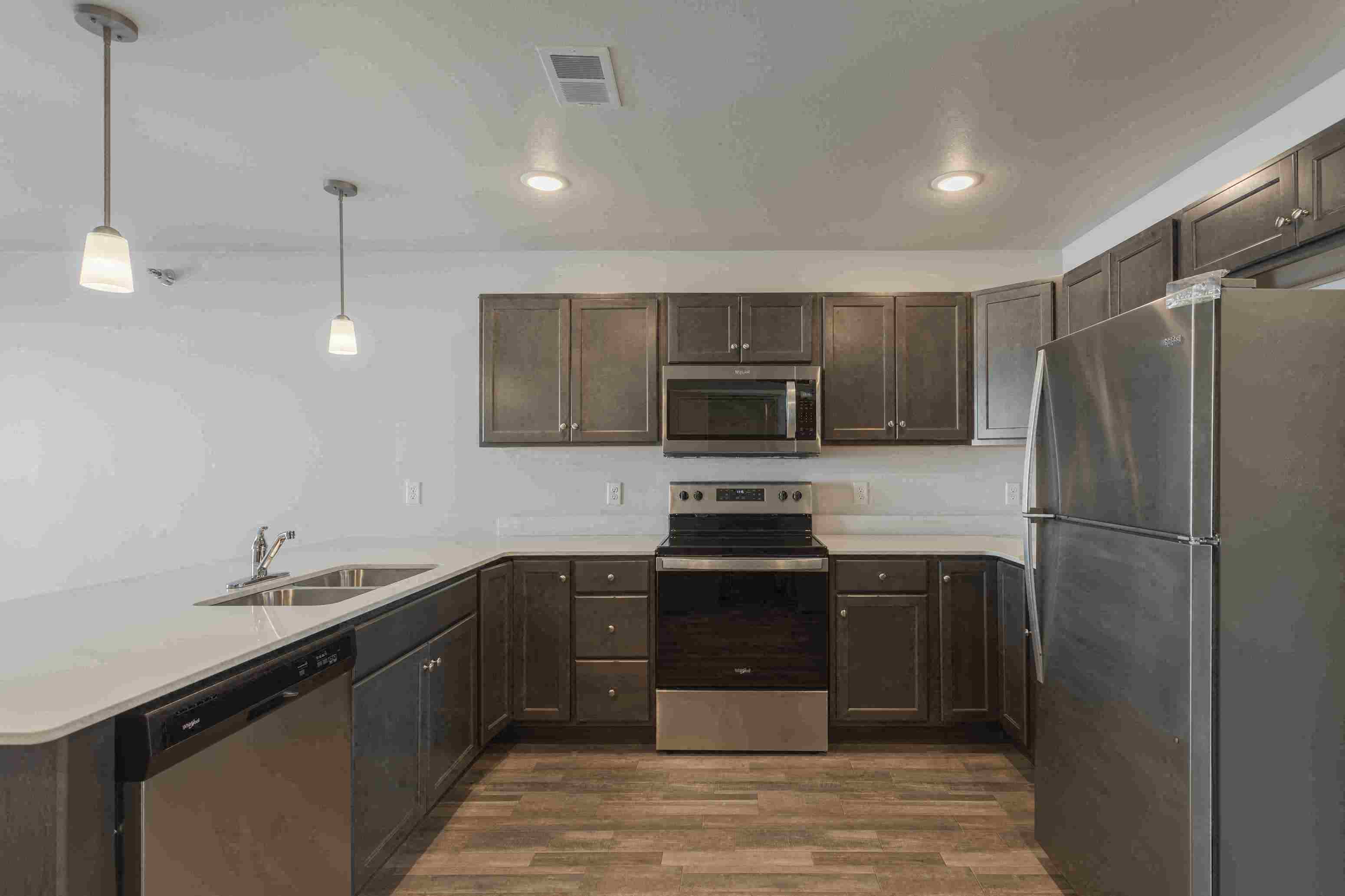 a kitchen with dark wood cabinets and stainless steel appliances