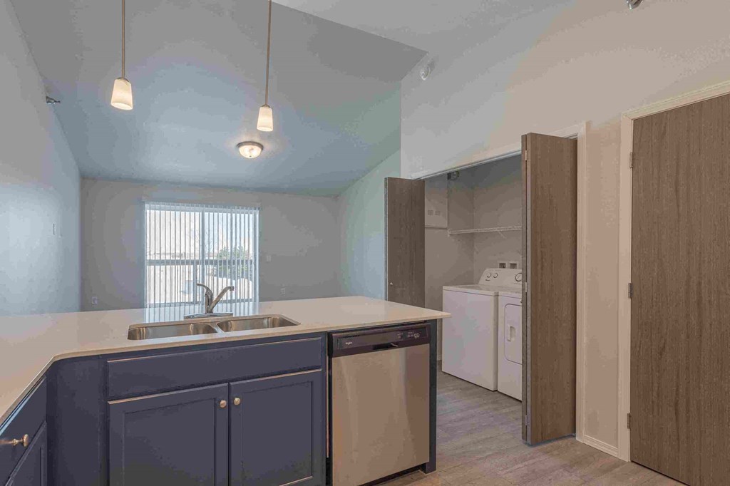 a kitchen with a sink and cabinets and a window