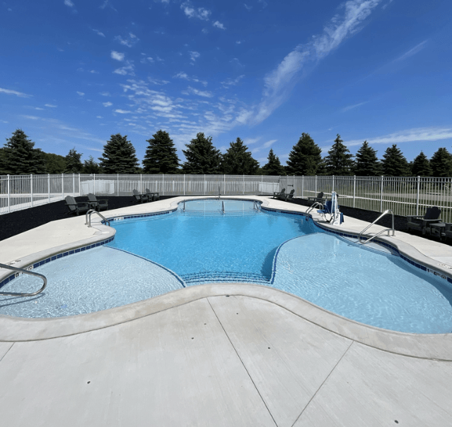 A large outdoor swimming pool surrounded by a fence.