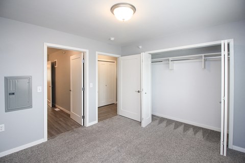A white room with a grey carpet and a white door.