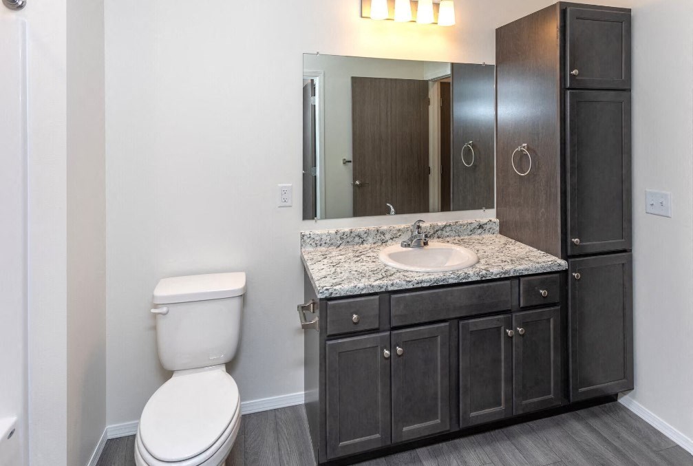 a bathroom with a sink toilet and a mirror