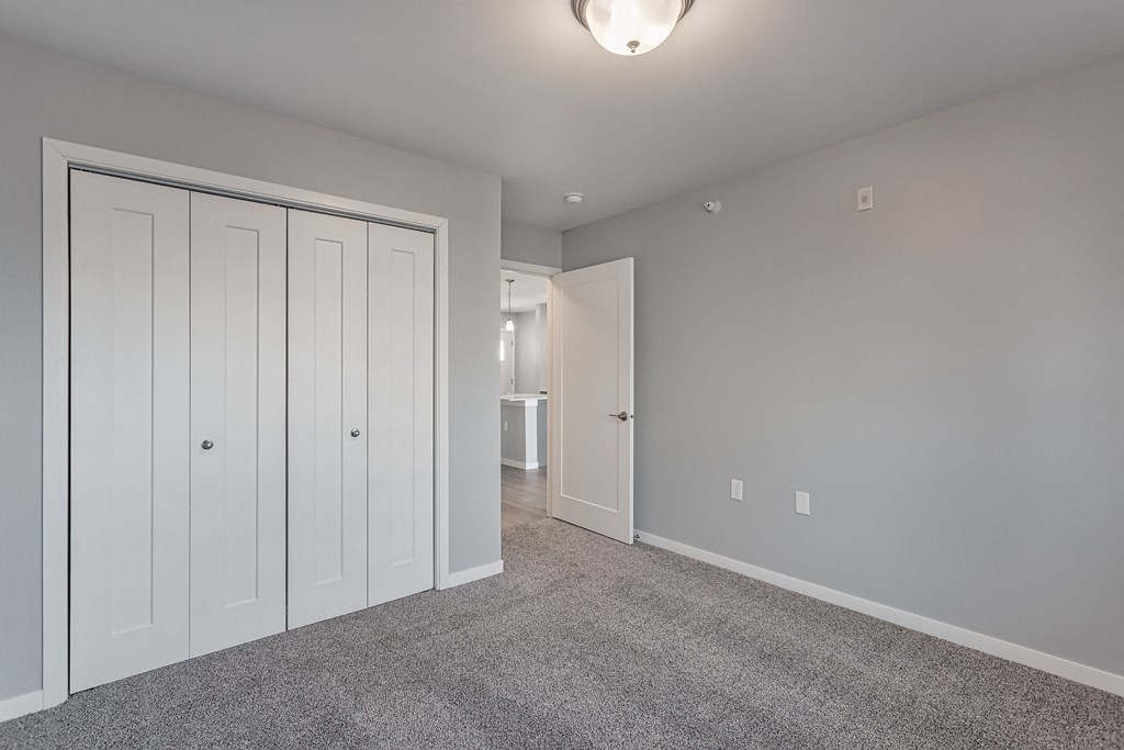 a bedroom with two closets and a carpeted floor