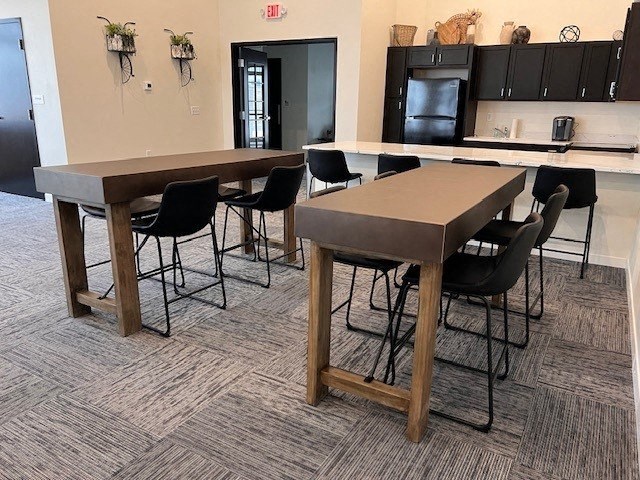 two tables and chairs in a room with a kitchen
