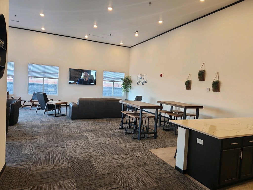 A conference room with a large table, chairs, and a TV on the wall.