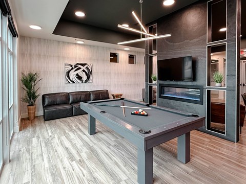 A room with a pool table and a fireplace.