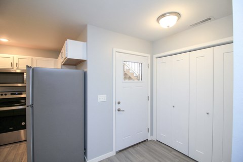 A kitchen with a refrigerator, oven, and cabinets.