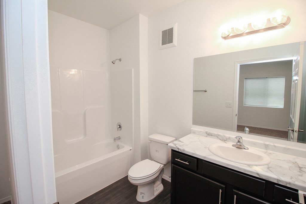 A white bathroom with a toilet, sink, and bathtub.