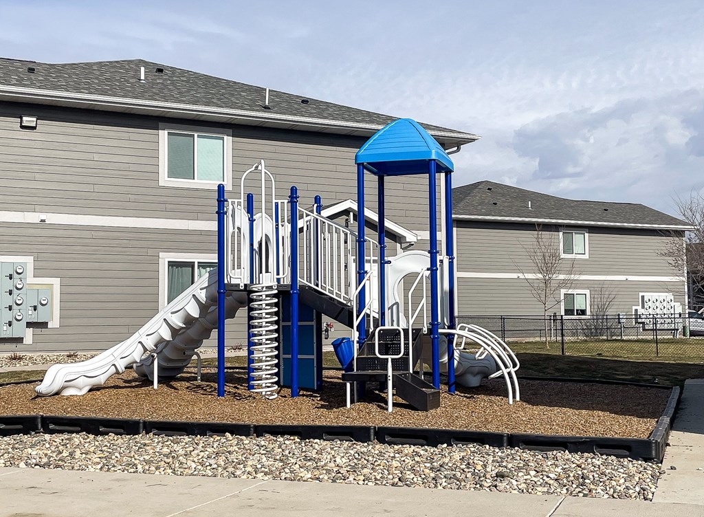 A playground with a blue structure and a slide.
