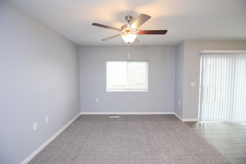 A room with a ceiling fan and a window.