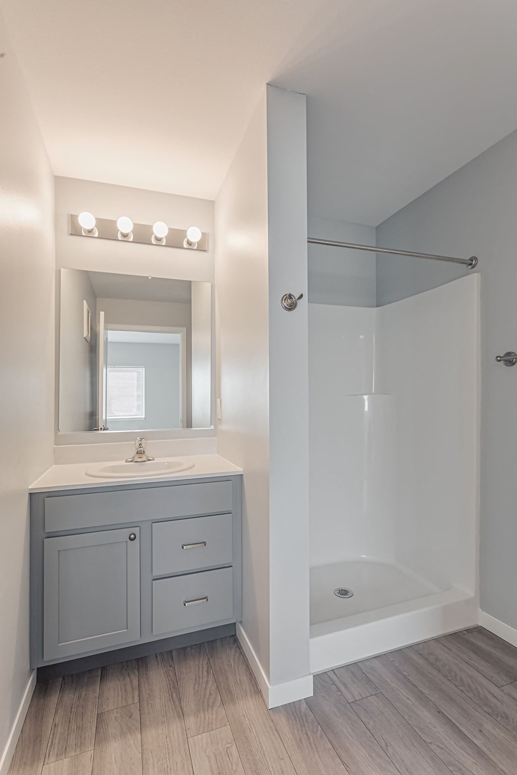 a bathroom with a sink and a shower and a mirror