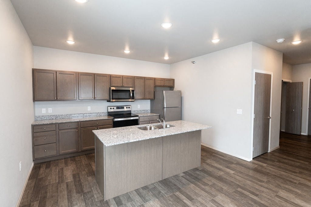 a kitchen with an island and stainless steel appliances